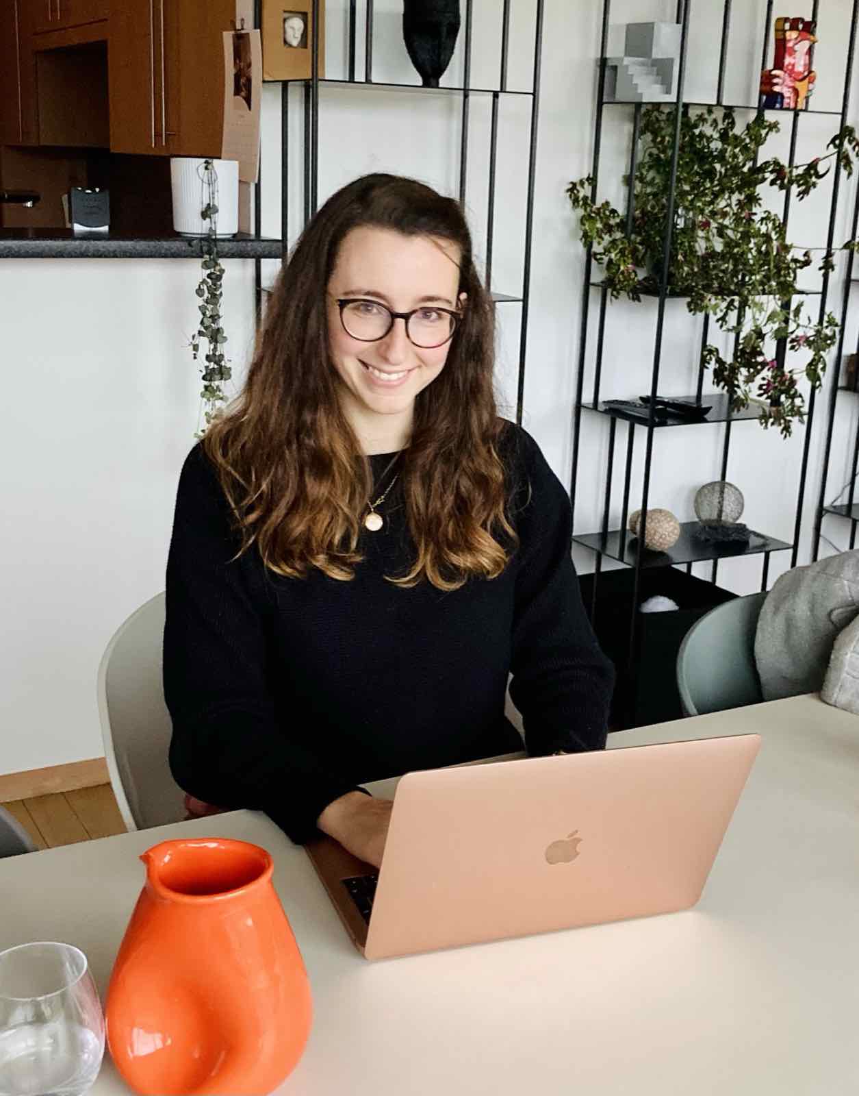 Annelies lacht achter haar laptop