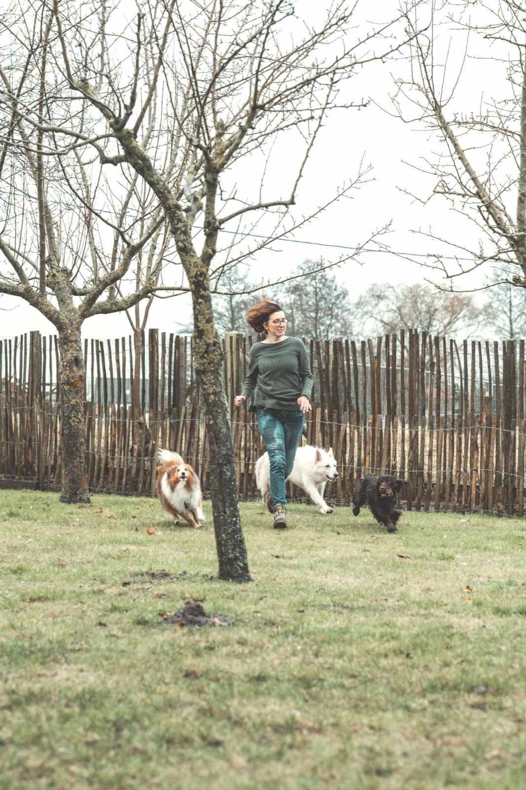 Annelies loopt met haar honden door de tuin