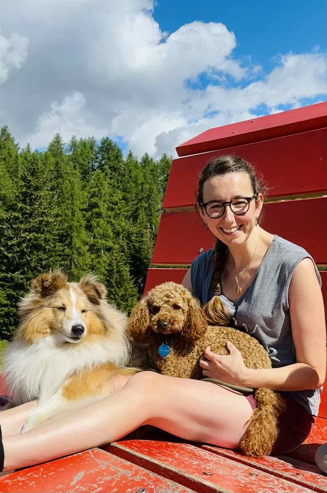 Annelies lacht op een rode bank in de bergen met Billie en Amedee