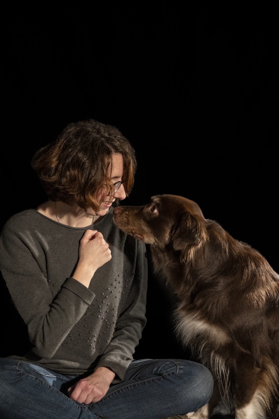 Een hond legt zijn snoet tegen het gezicht van Annelies
